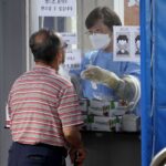 Seoul :A medical worker conducts a coronavirus test on a man at a screening clinic in Seoul’s Gwanak Ward on July 13, 2022.(Photo:Yonhap/IANS)